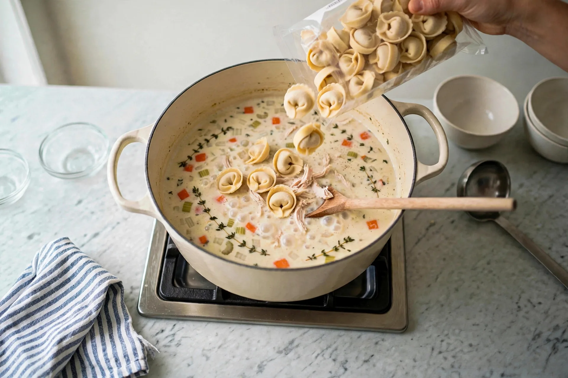 Pouring cheese tortellini into simmering soup